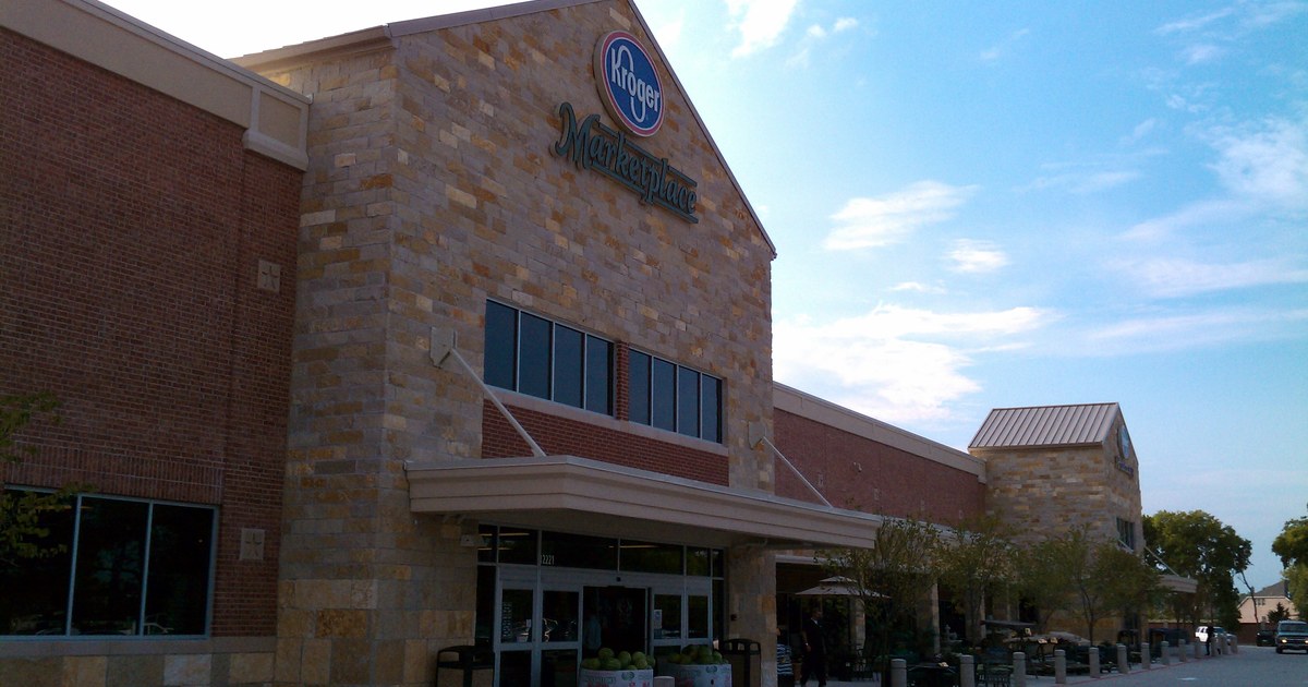 Kroger Marketplace store exterior with stone and brick facade under a blue sky